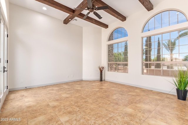 empty room featuring ceiling fan and beamed ceiling