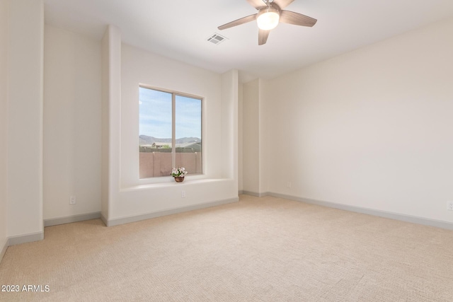 spare room with light carpet and ceiling fan