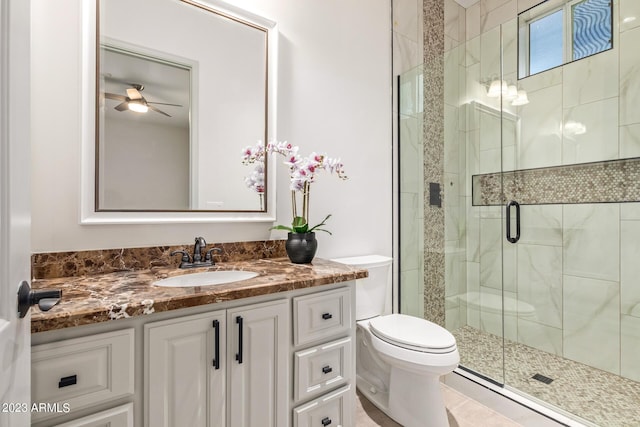 bathroom featuring vanity, a shower with door, toilet, and ceiling fan