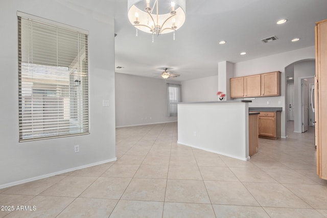 kitchen with ceiling fan with notable chandelier, kitchen peninsula, light tile patterned floors, and decorative light fixtures