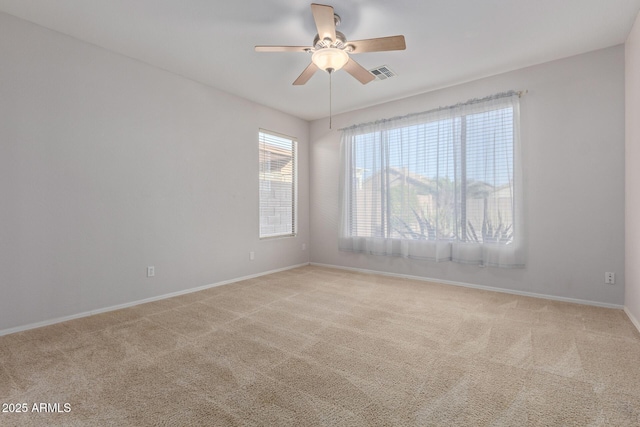 spare room with ceiling fan and light colored carpet