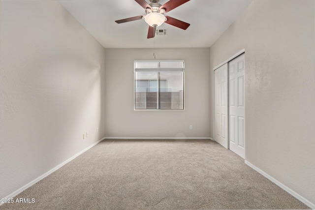 unfurnished bedroom with ceiling fan, a closet, and light carpet