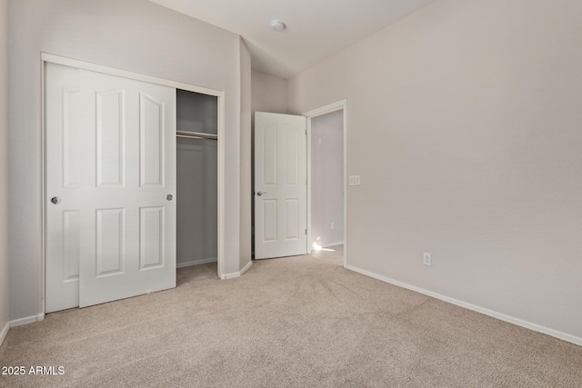 unfurnished bedroom featuring a closet and light carpet