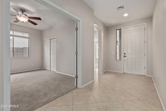 foyer entrance with light carpet and ceiling fan