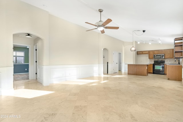 unfurnished living room with sink, ceiling fan, and lofted ceiling