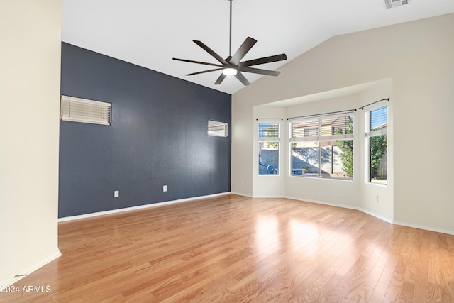 spare room featuring light wood-type flooring, vaulted ceiling, and ceiling fan