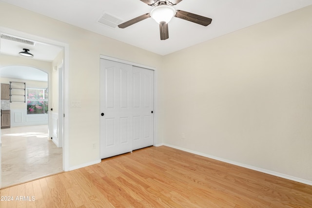 unfurnished bedroom featuring light hardwood / wood-style floors, a closet, and ceiling fan