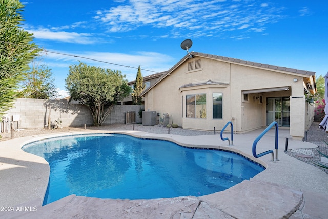 view of swimming pool with a patio and central air condition unit