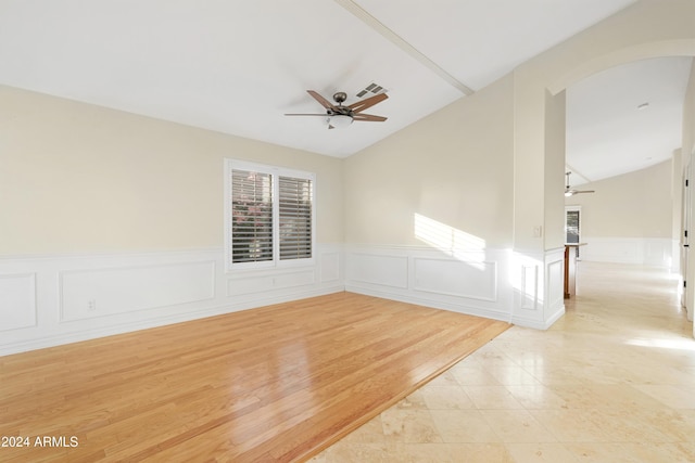 tiled empty room with vaulted ceiling and ceiling fan