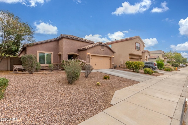mediterranean / spanish house featuring a tile roof, stucco siding, driveway, and an attached garage