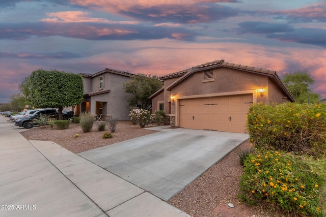ranch-style house featuring an attached garage, concrete driveway, and stucco siding