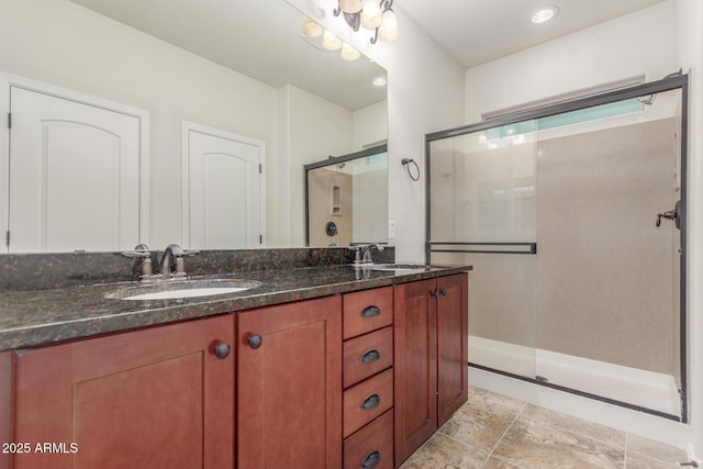 bathroom with double vanity, an enclosed shower, and a sink