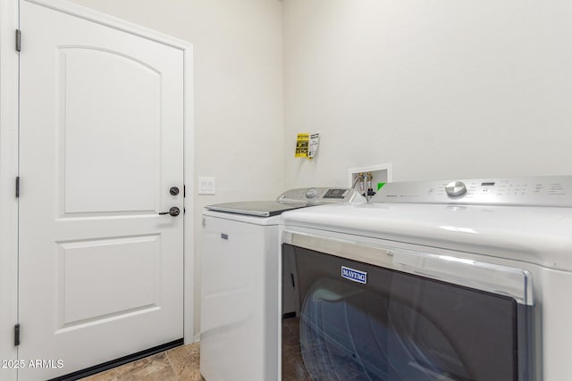 clothes washing area with washing machine and clothes dryer and laundry area