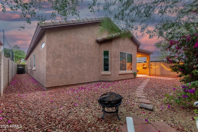 back of house with stucco siding and a fenced backyard