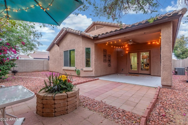 rear view of house with stucco siding, a patio, french doors, and central AC