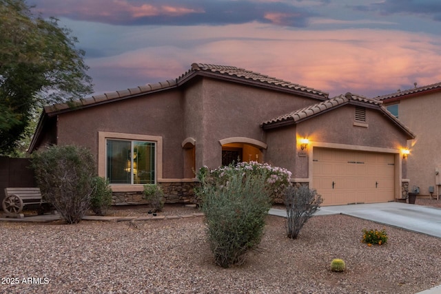 mediterranean / spanish-style home featuring driveway, stucco siding, and a garage