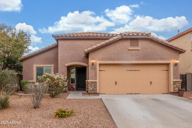 mediterranean / spanish home with concrete driveway, stone siding, a tile roof, stucco siding, and a garage