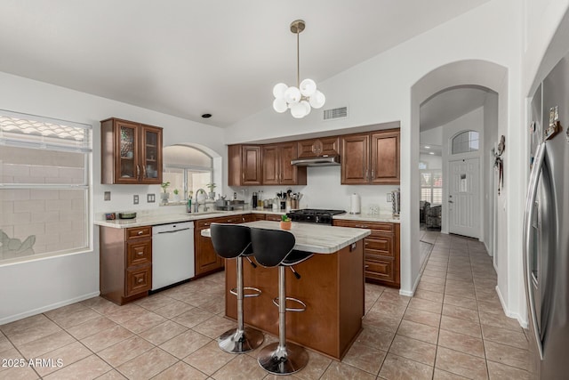 20424 N 96th Ln, Peoria, AZ 85382 - kitchen featuring white dishwasher, arched walkways, lofted ceiling, light tile patterned floors, and a center island