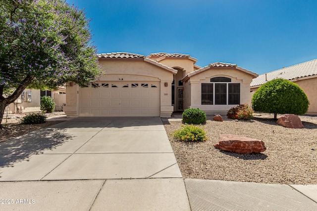 20424 N 96th Ln, Peoria, AZ 85382 - mediterranean / spanish-style house featuring stucco siding, an attached garage, concrete driveway, and a tiled roof