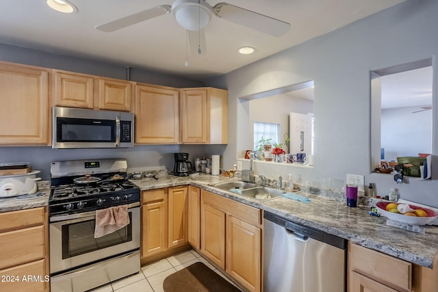 kitchen with light brown cabinetry, stainless steel appliances, ceiling fan, sink, and light tile patterned flooring