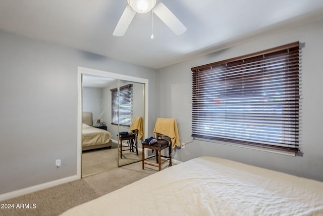 carpeted bedroom featuring ceiling fan and a closet