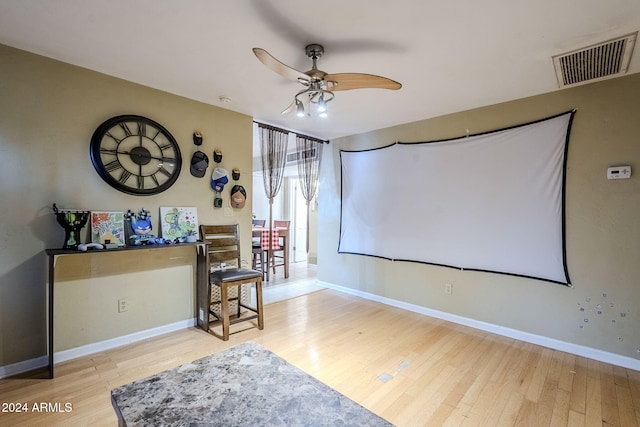 cinema room featuring ceiling fan and light wood-type flooring