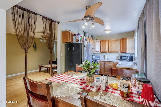 kitchen with stainless steel fridge, light hardwood / wood-style flooring, ceiling fan, and sink