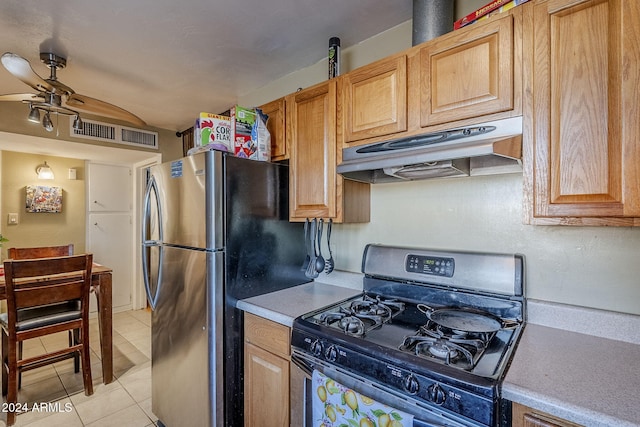 kitchen featuring stainless steel refrigerator, black range with gas stovetop, ceiling fan, and light tile patterned flooring