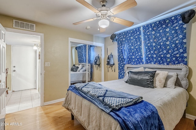 bedroom with hardwood / wood-style floors, ceiling fan, and a closet