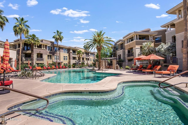 community pool with a patio area and fence