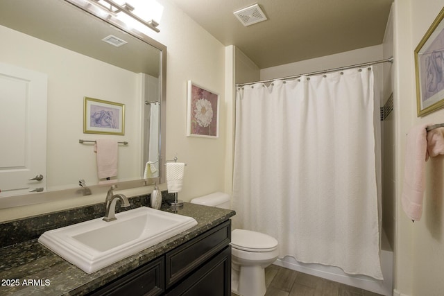 bathroom featuring toilet, vanity, wood finished floors, and shower / tub combo with curtain