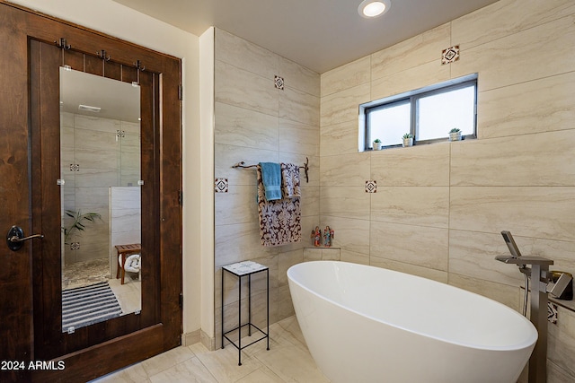 bathroom featuring a freestanding tub, tiled shower, and tile walls