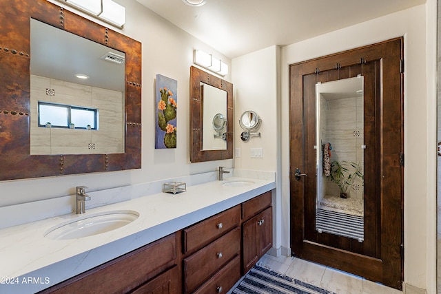 full bath with a sink, visible vents, double vanity, and a tile shower