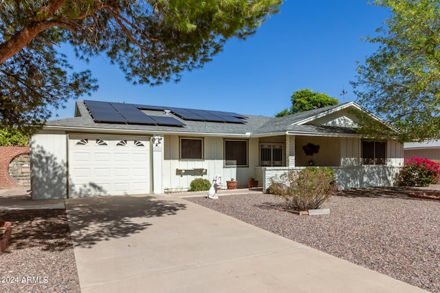 single story home with a garage, solar panels, and a porch