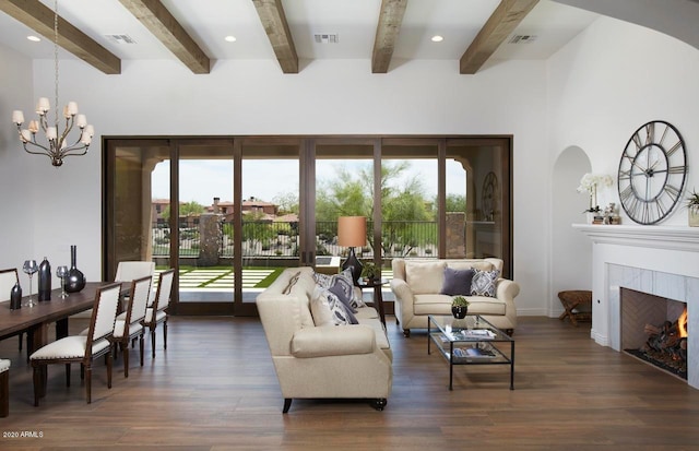 living room with beam ceiling, a notable chandelier, dark hardwood / wood-style floors, and a tile fireplace