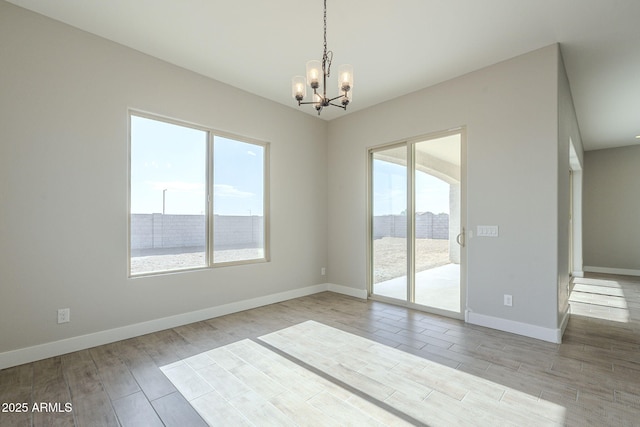 unfurnished room with a notable chandelier and a healthy amount of sunlight