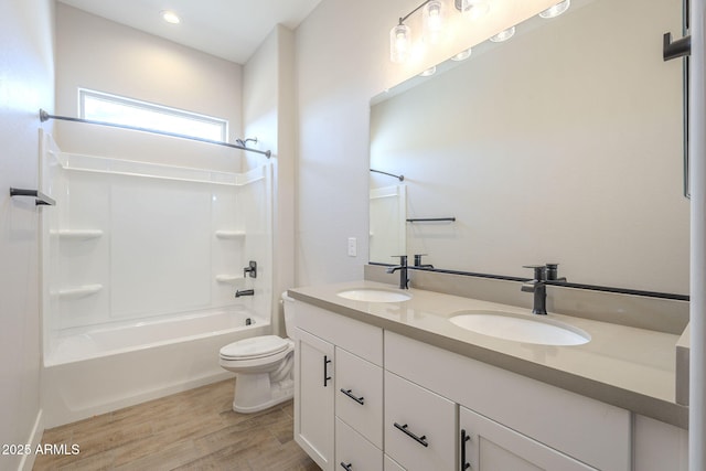 full bathroom featuring hardwood / wood-style flooring, vanity, toilet, and washtub / shower combination