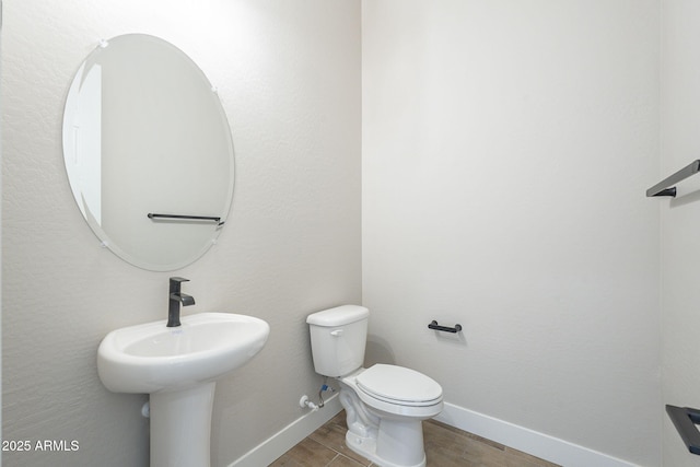 bathroom with hardwood / wood-style flooring and toilet