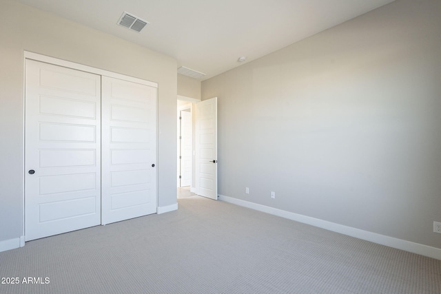 unfurnished bedroom with light carpet and a closet