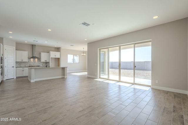 unfurnished living room with sink, a water view, and an inviting chandelier