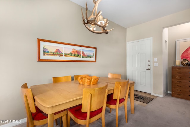 carpeted dining area with a notable chandelier