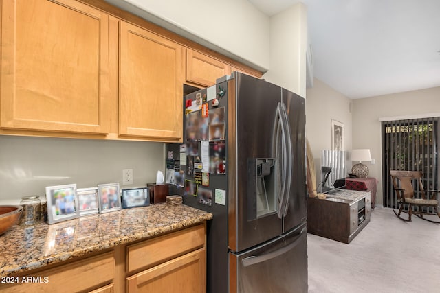 kitchen with light stone countertops and stainless steel refrigerator with ice dispenser