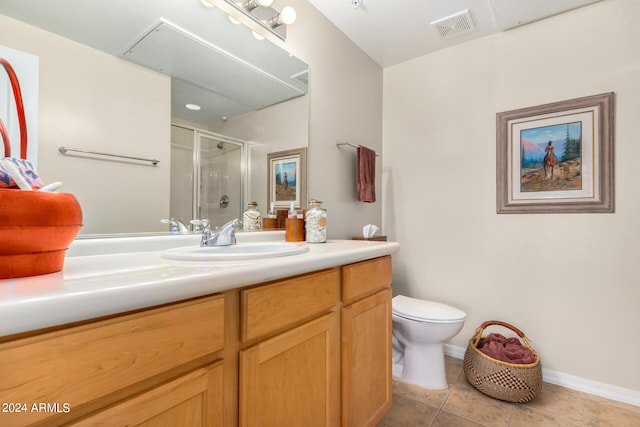 bathroom featuring vanity, toilet, tile patterned floors, and a shower with shower door