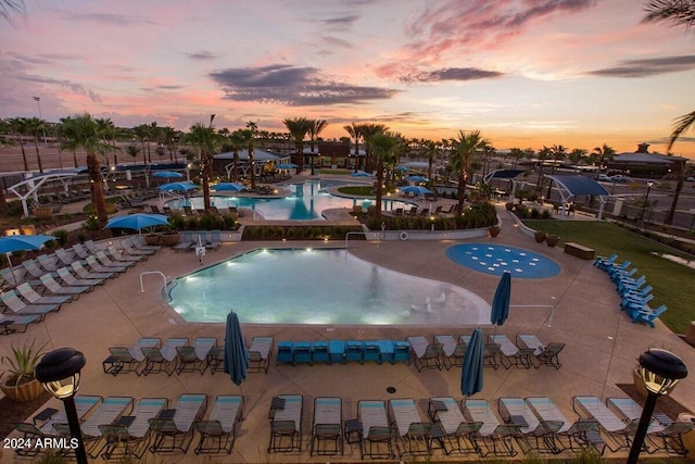 pool at dusk featuring a patio area