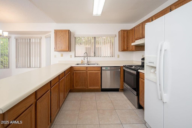 kitchen with under cabinet range hood, stainless steel appliances, a sink, and light countertops