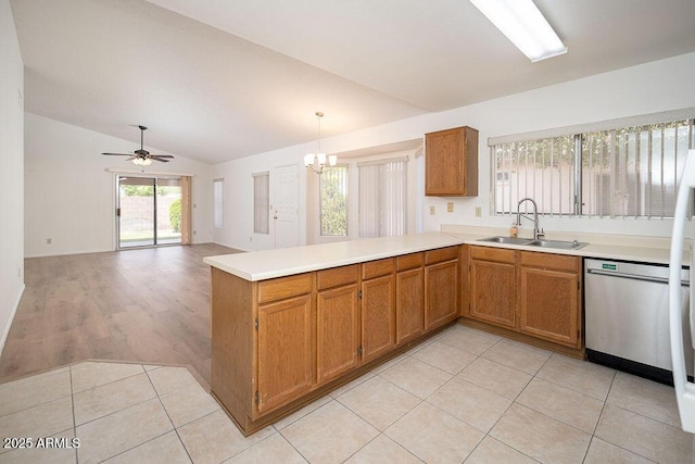 kitchen with a sink, dishwasher, light countertops, a peninsula, and lofted ceiling