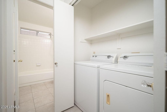 clothes washing area featuring washing machine and clothes dryer, laundry area, and light tile patterned floors