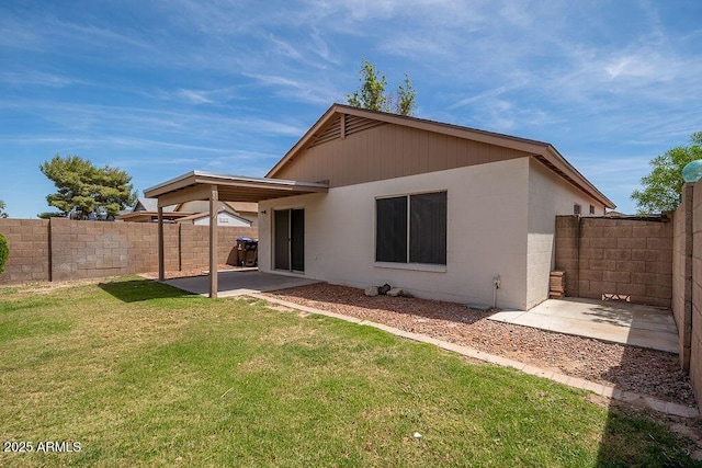 rear view of house featuring a fenced backyard, concrete block siding, a patio area, and a yard