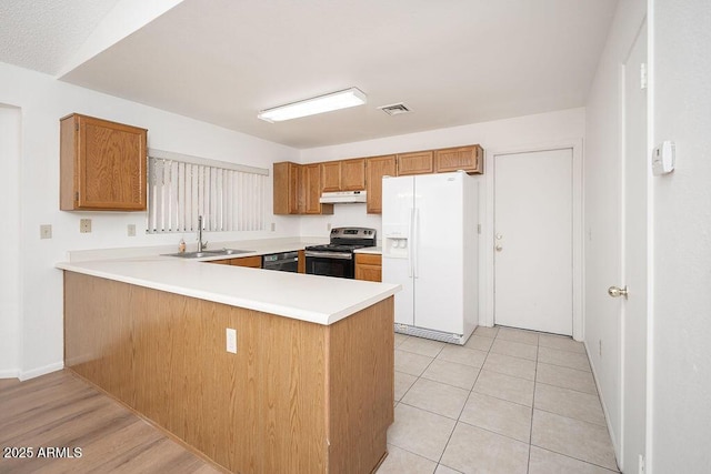 kitchen with white refrigerator with ice dispenser, stainless steel electric range, a sink, a peninsula, and under cabinet range hood