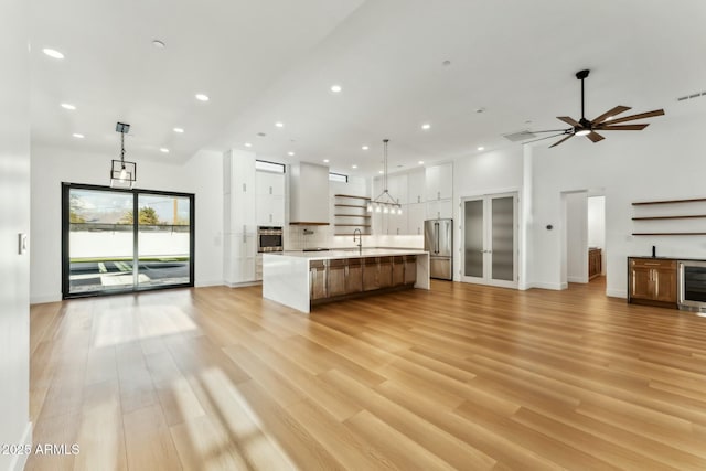 kitchen with white cabinetry, appliances with stainless steel finishes, pendant lighting, and a spacious island